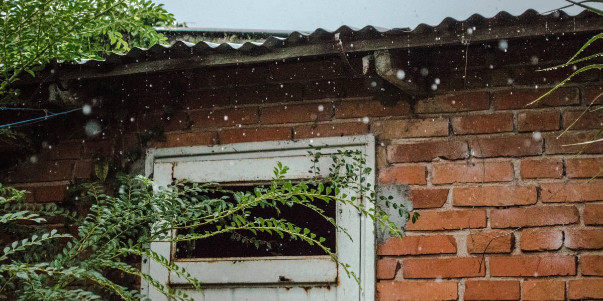Partial picture of a house and roof with visible rain